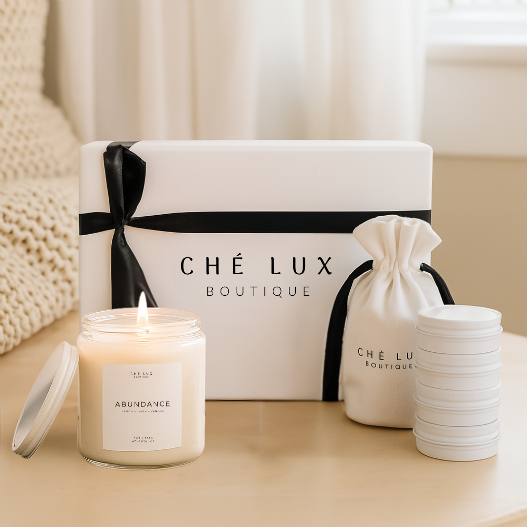 Candle with 'Ché Lux Boutique' branding on a neutral background